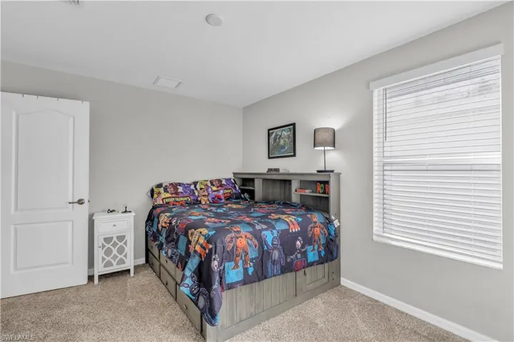 Carpeted bedroom featuring multiple windows