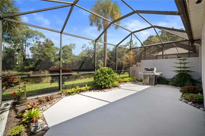 View of patio / terrace featuring a grill, glass enclosure, a sunroom, and a water view