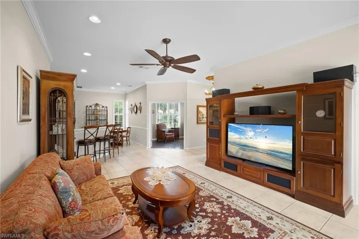 Living area featuring crown molding, light tile patterned floors, a ceiling fan, and recessed lighting