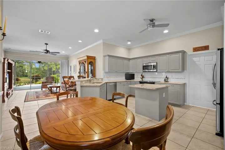 Dining space featuring ceiling fan, ornamental molding, recessed lighting, and light tile patterned flooring