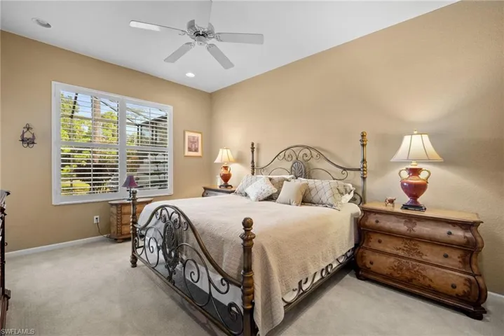 Bedroom featuring light colored carpet, a ceiling fan, and recessed lighting