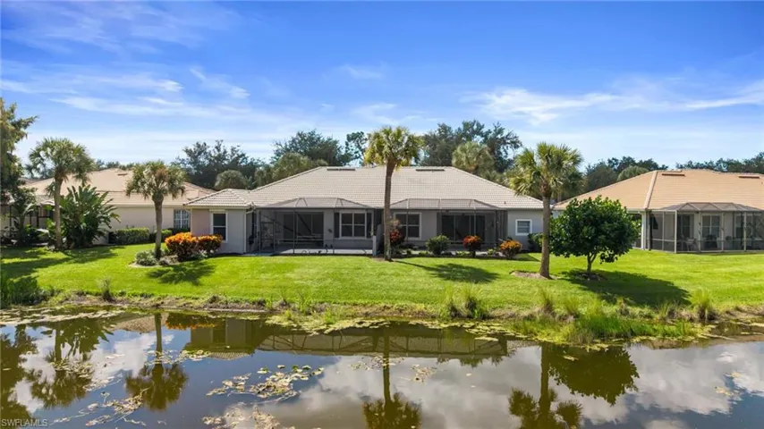 Rear view of property featuring a sunroom, a yard, and a lanai
