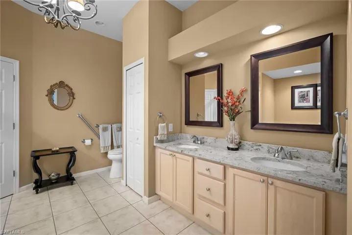 Full bath with double vanity, light tile patterned floors, a chandelier, a closet, and recessed lighting