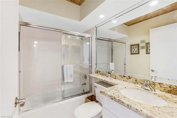 Bathroom with vanity, combined bath / shower with glass door, and recessed lighting