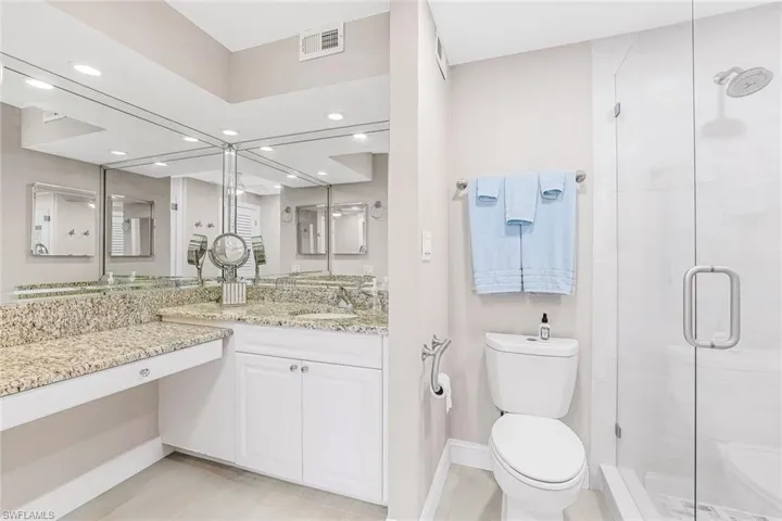 Full bathroom with vanity, a stall shower, and recessed lighting