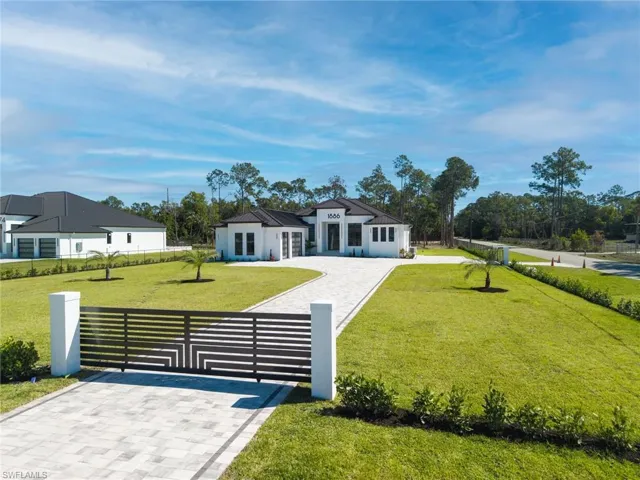 Modern home with 2 electric gates and beautiful landscaping.