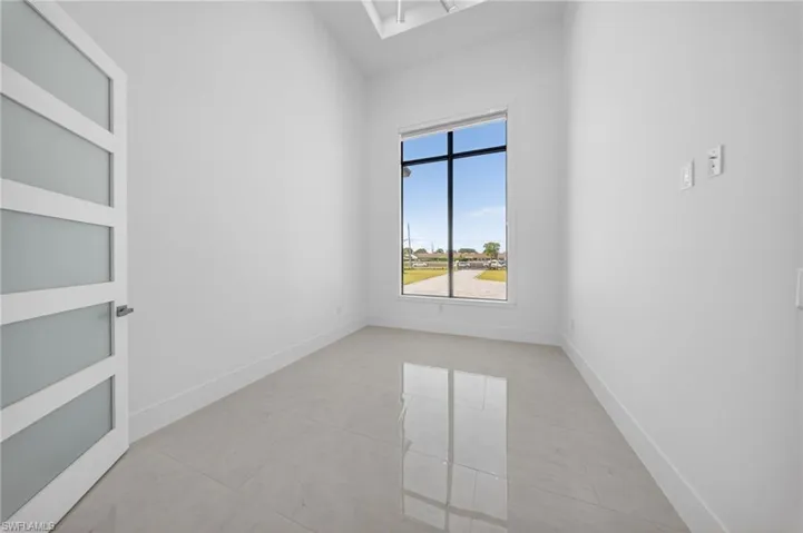 Den/Office space with plenty of natural light. Has curtains and a ceiling fan.