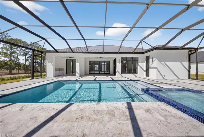 Combined pool / 360 spill over spa within a screen enclosure. A patio area with summer kitchen. Marble decking throughout.