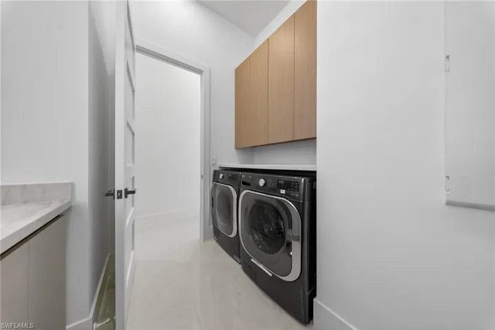 Laundry area featuring cabinet space with washing machine and dryer.