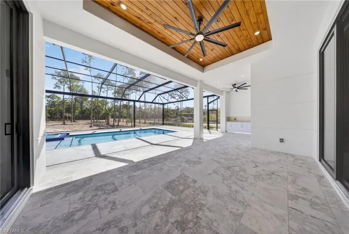 Outdoor patio featuring a wood paneled ceiling. Two ceiling fans.