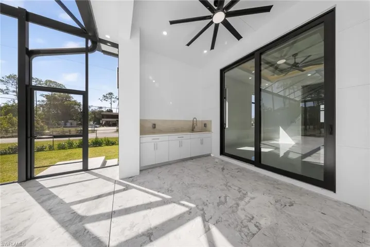 Patio area with summer kitchen and ceiling fans.