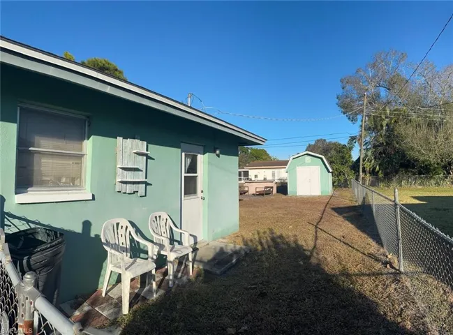 View of side of home with a shed and stucco siding