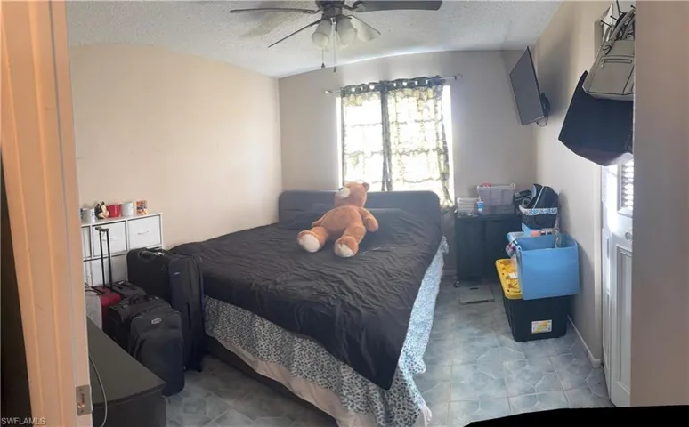 Bedroom with a textured ceiling and ceiling fan