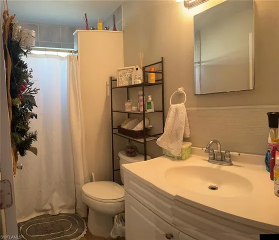 Full bath with a shower with curtain and vanity