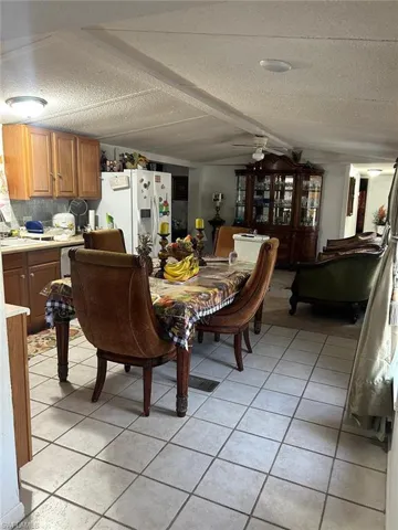 Dining space featuring ceiling fan, light tile patterned floors, and a textured ceiling
