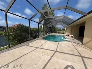 Outdoor pool featuring a patio and glass enclosure