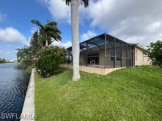 View of yard featuring a lanai and a water view