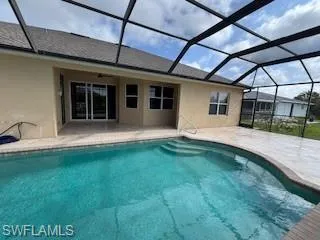Outdoor pool with a patio and glass enclosure