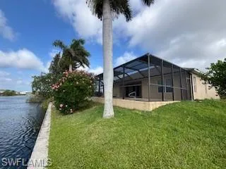 View of yard featuring a water view and glass enclosure