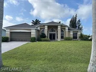 View of front facade featuring driveway, a garage, stucco siding, and a front yard