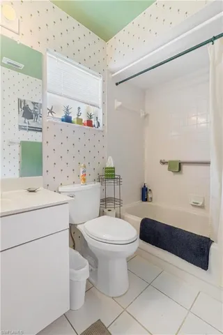Full bathroom with vanity, toilet, tile patterned floors, and shower / tub combo