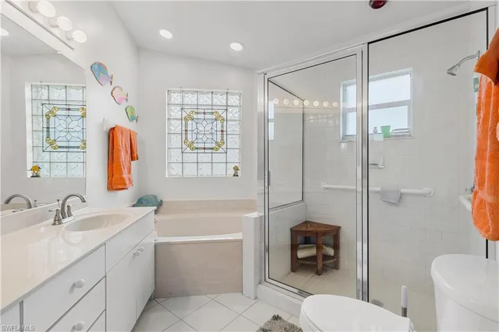 Full bathroom with vanity, a wealth of natural light, tile patterned flooring, and toilet