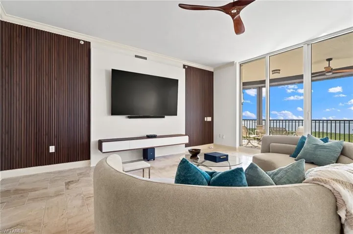 Living area featuring crown molding, a wall of windows, and a ceiling fan