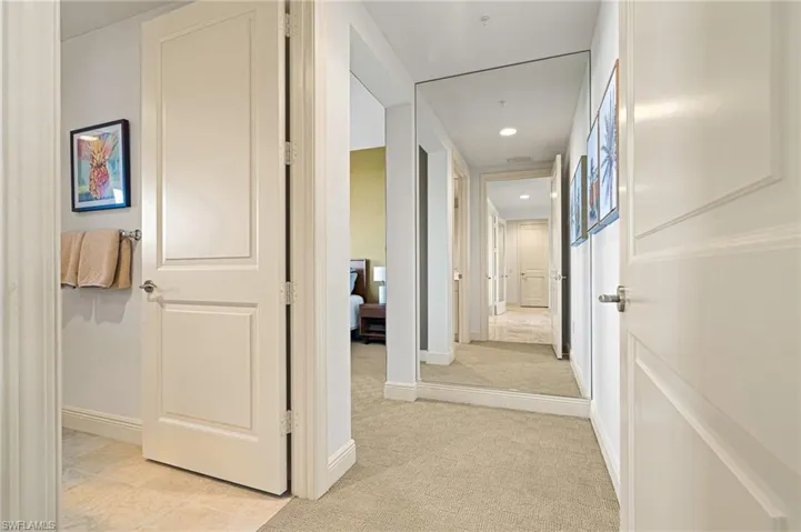 Corridor with light colored carpet and recessed lighting
