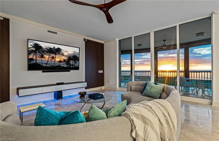 Living area with floor to ceiling windows, ornamental molding, and ceiling fan