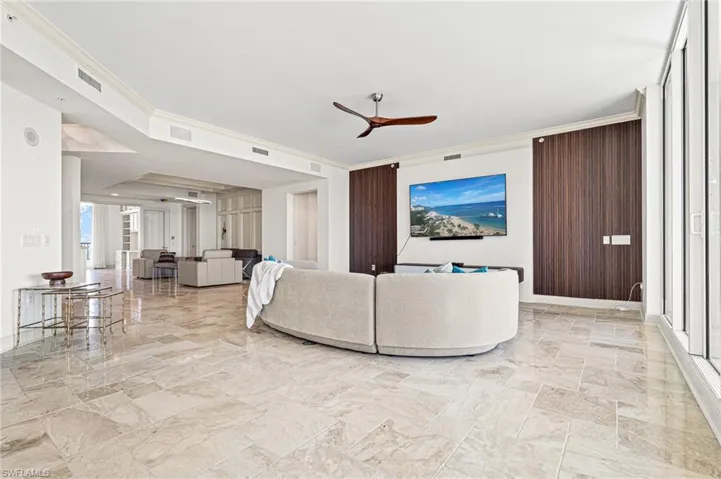 Living area featuring ceiling fan and ornamental molding