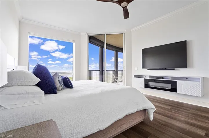 Bedroom featuring ornamental molding, dark wood-style floors, ceiling fan, and access to outside