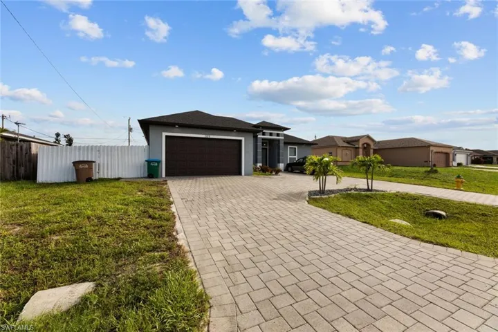 Ranch-style house featuring a garage and a front yard