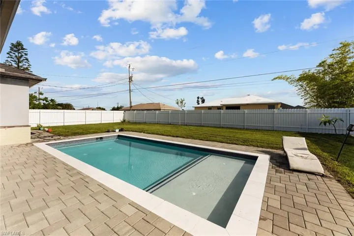 View of swimming pool featuring a patio and a yard