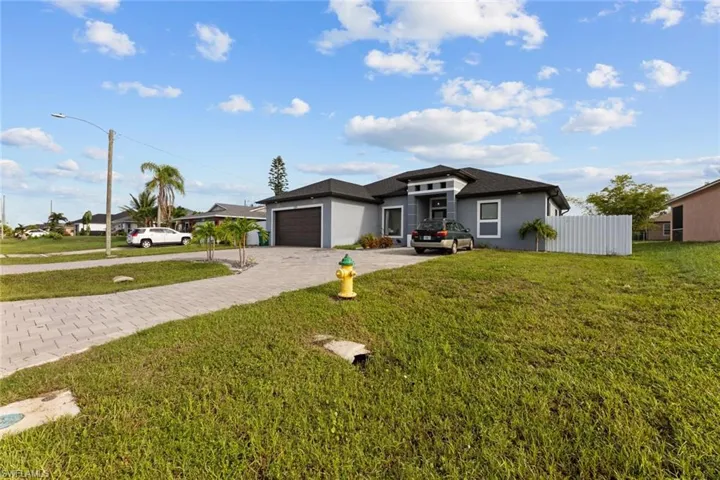 View of front of property featuring a front lawn and a garage