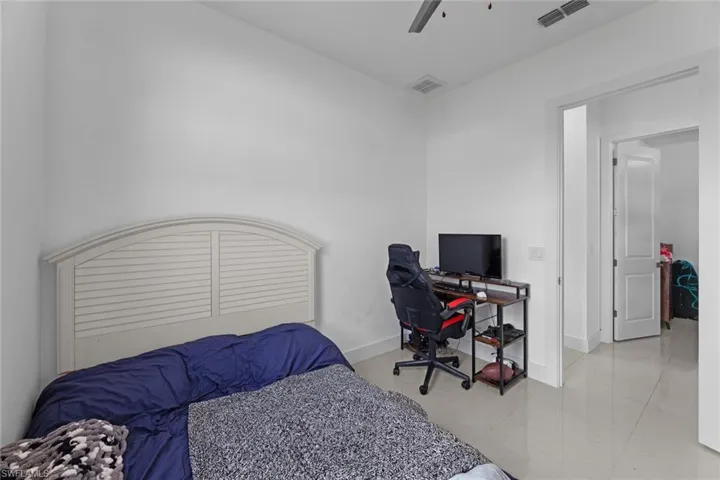 Bedroom with light tile flooring and ceiling fan
