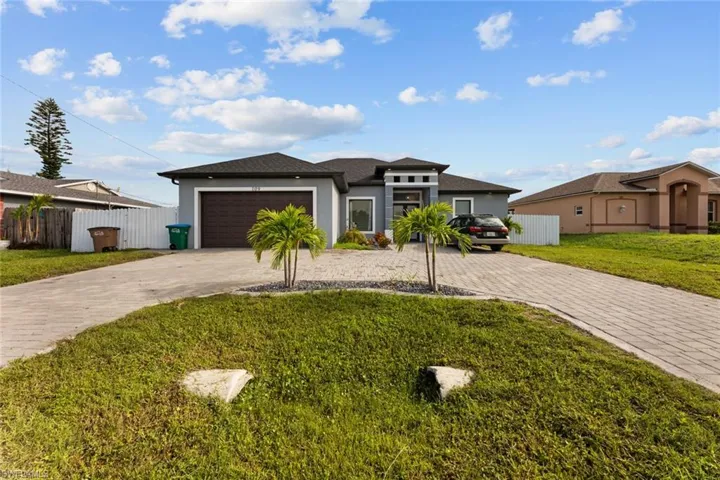 View of front of house featuring a garage and a front lawn