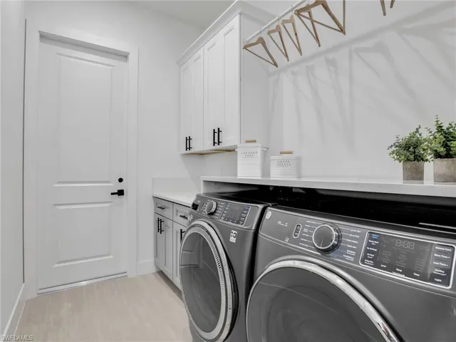 Laundry room featuring washing machine and clothes dryer and cabinet space