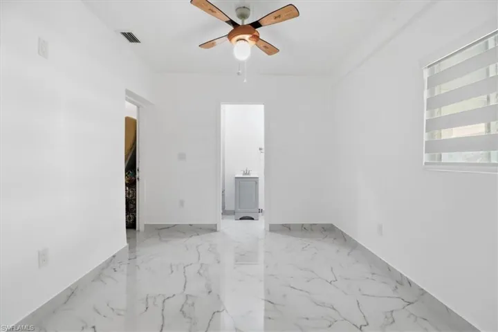 Spare room featuring ceiling fan and light marble finish floors
