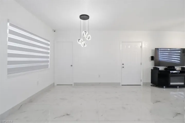 Dining space featuring light marble finish flooring and a chandelier