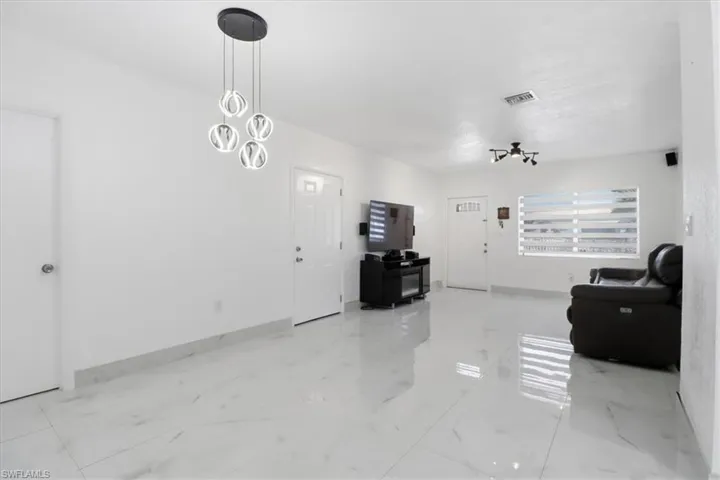 Living area featuring a chandelier and light marble finish floors