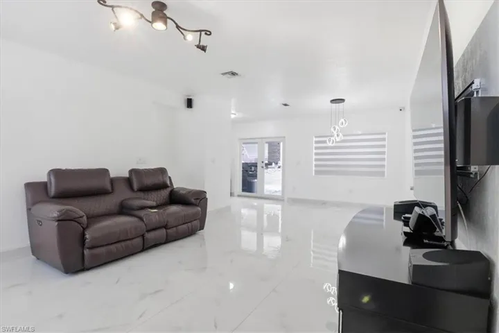 Living room featuring light marble finish flooring and french doors
