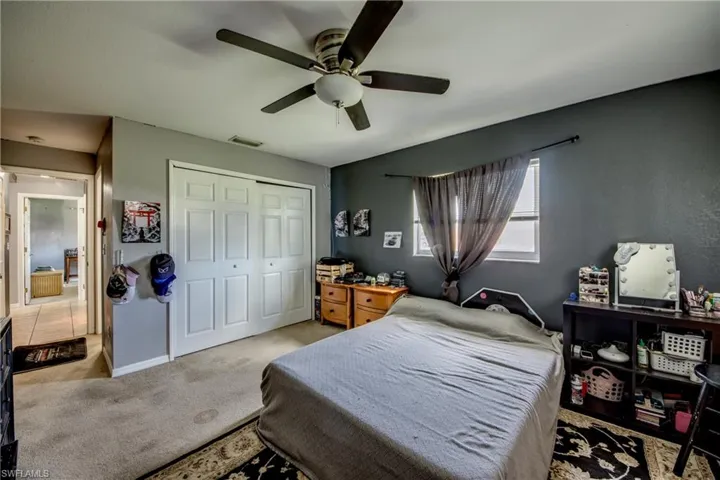 Bedroom featuring light carpet, a closet, and ceiling fan
