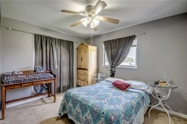 Carpeted bedroom featuring ceiling fan