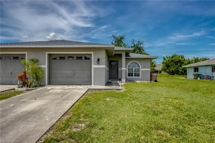 Single story home with a garage and a front lawn