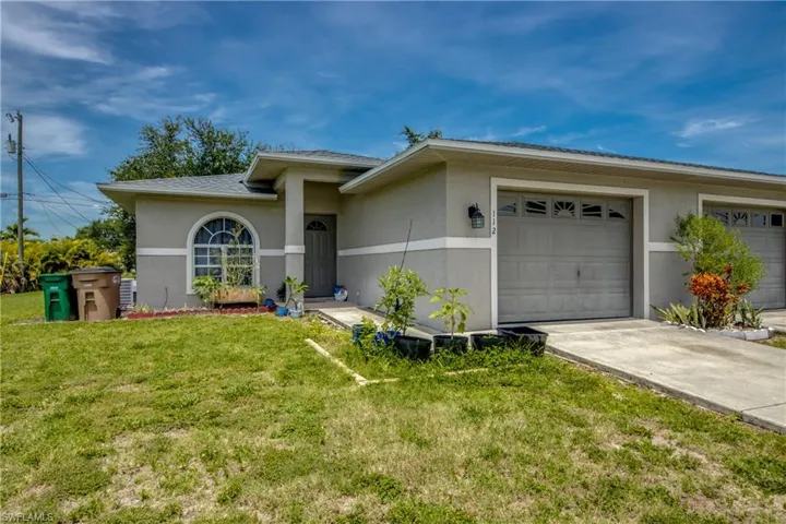 Ranch-style home featuring a garage and a front yard