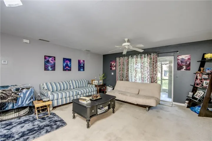 Living room featuring light colored carpet and ceiling fan
