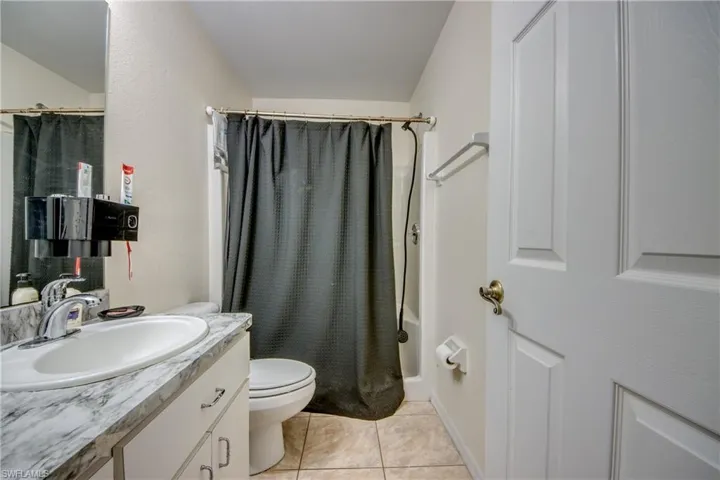 Bathroom featuring vanity, tile patterned flooring, and toilet