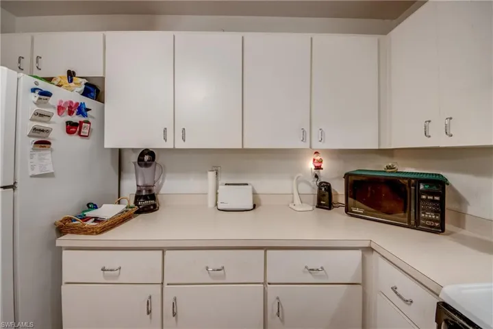 Kitchen featuring white cabinets and white refrigerator