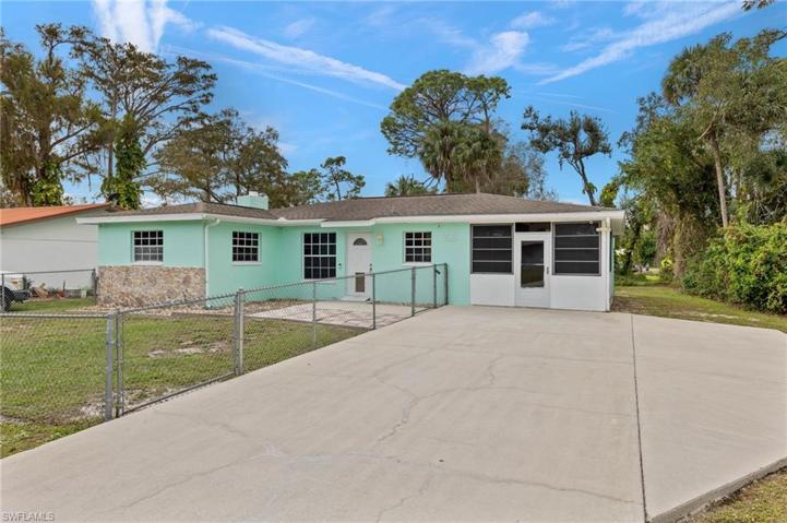 Front of home with fenced area and lots of parking.