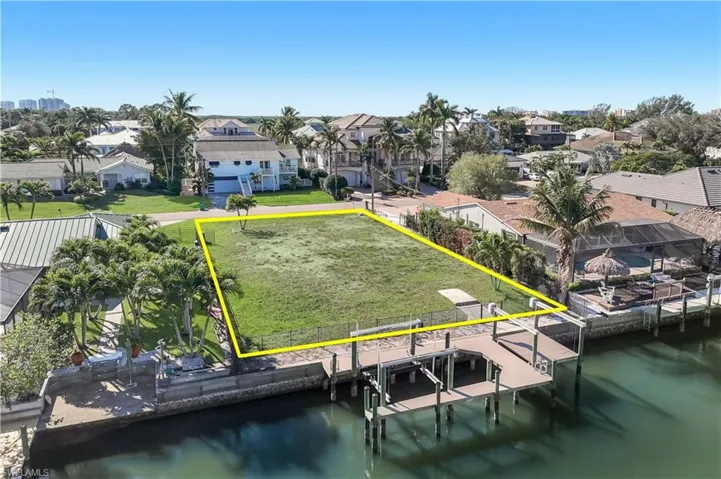 Waterfront parcel featuring a boat dock with a lift, direct canal access, and a clear, level building site - Virtually Edited Image